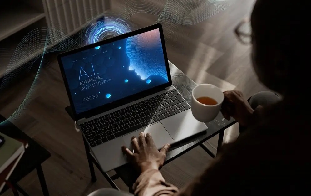 Мужчина пьет кофе и работает с ИИ за ноутбуком